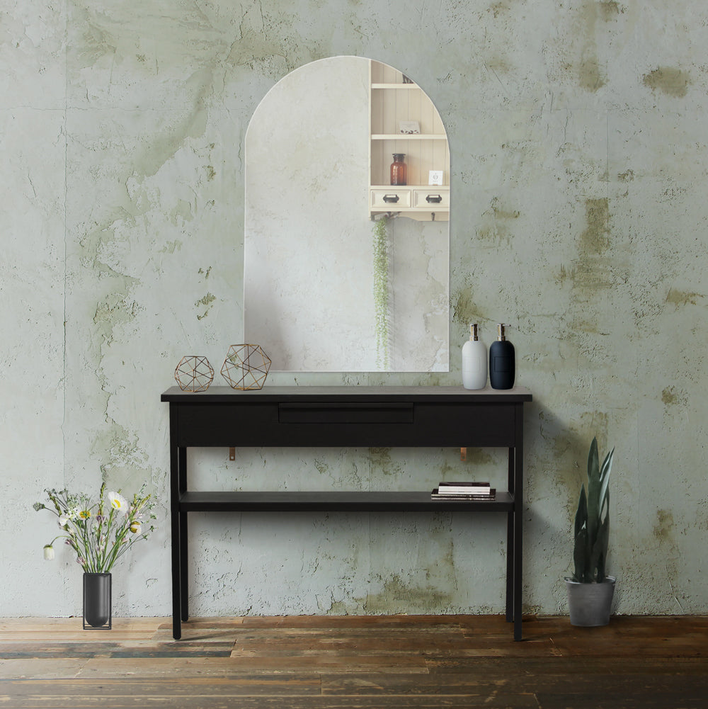 サロンにあるフレームレスアーチミラーとブラック色コンソール