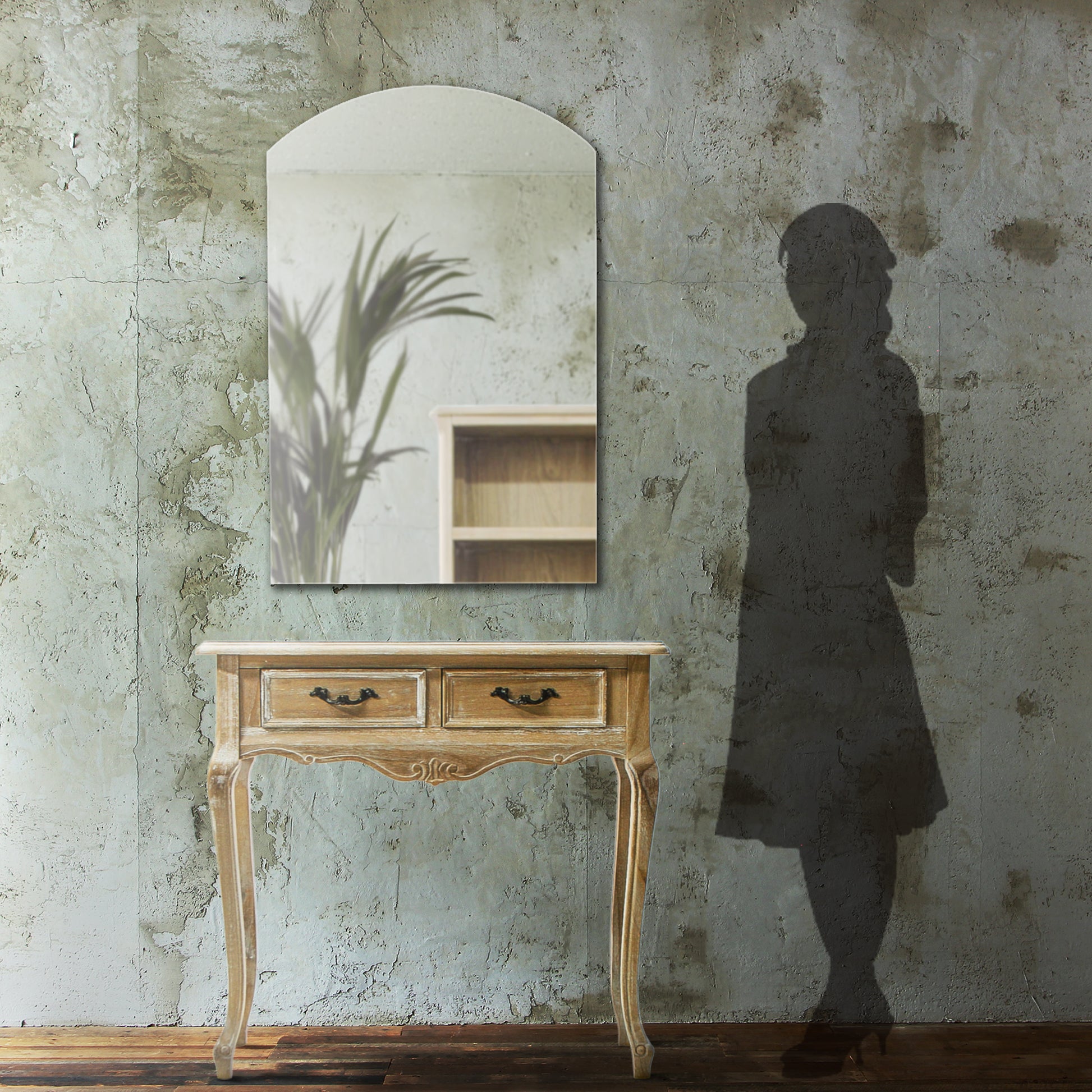 部屋にあるフレームレスアーチミラーとベージュコンソールとサイズがわかるための人シルエット