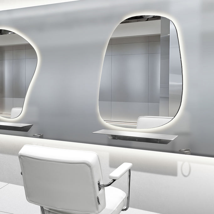 メタリックカラー美容室にあるシルバー色の壁付L型棚とウォールミラーとスタイリングチェア