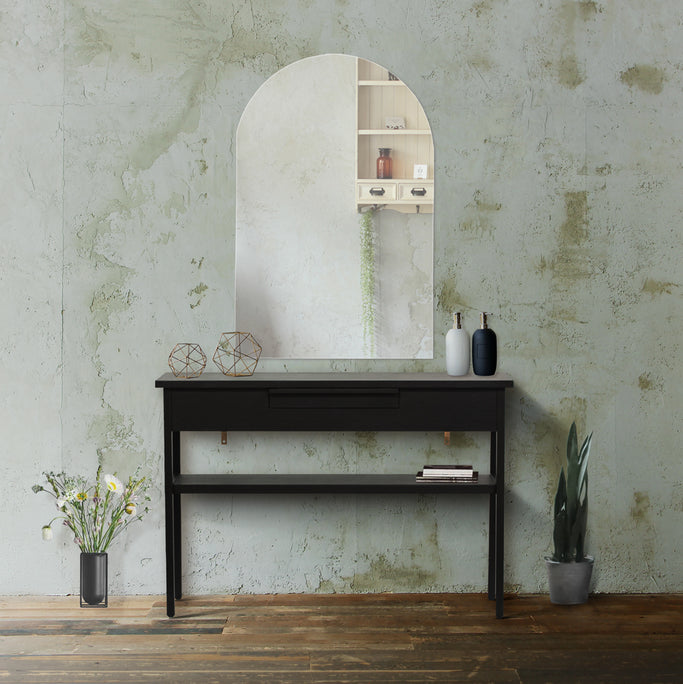 サロンにあるフレームレスアーチミラーとブラック色コンソール