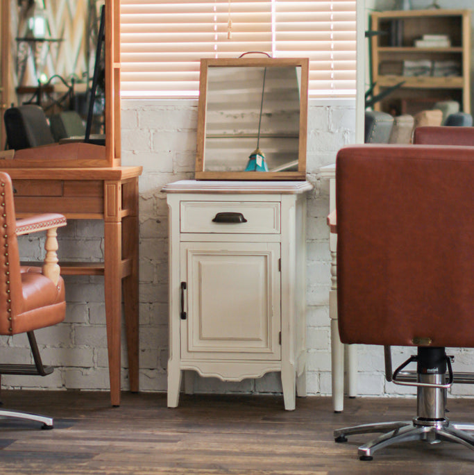 サロンにあるホワイト色サイドテーブルとハンドミラー