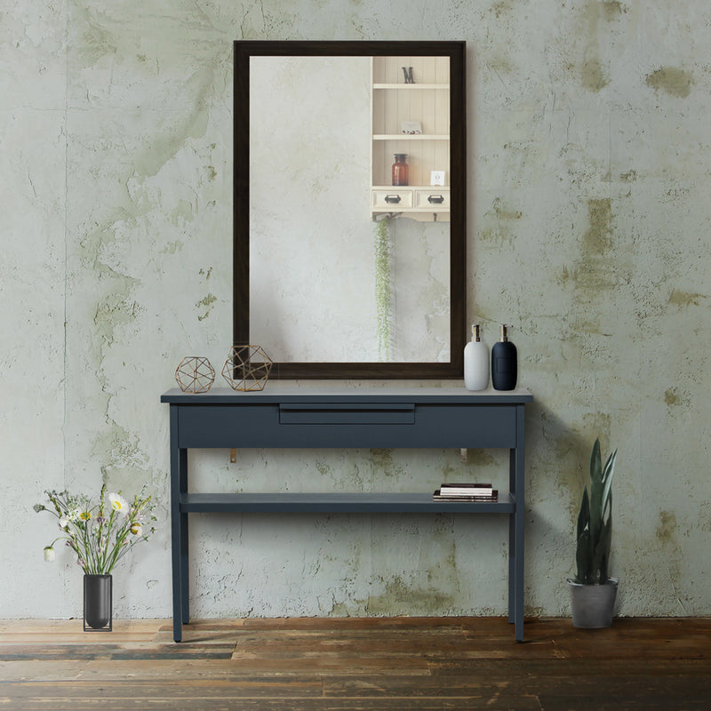 サロンにあるグレー色ワイドコンソールと壁掛けミラー